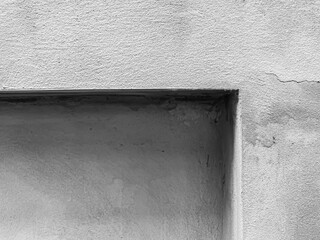 Abstract gradient, tone and depth of rough and cracks surface textured cement or concrete wall background in monochrome.