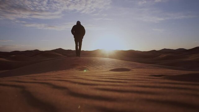  man walking on the top of the sand dunes of the Thar desert 