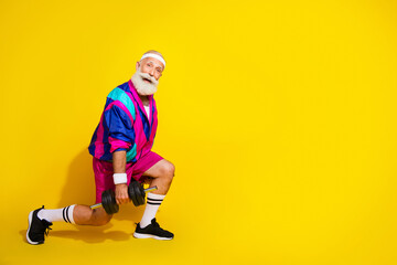 Full size photo poster of cheerful granddad sportsman dumbbell lunge squats wear vintage sportswear isolated on yellow color background