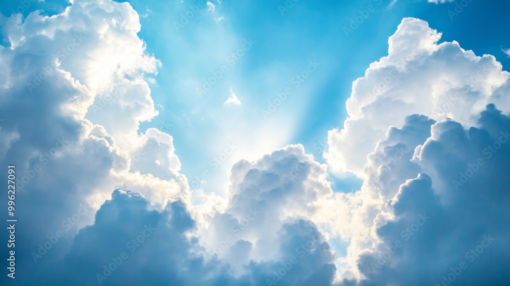 Poster a breathtaking view of fluffy white clouds against a deep blue sky, with sunlight streaming through,