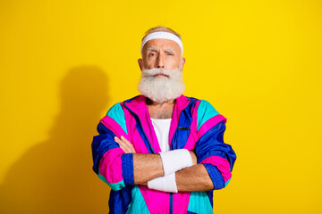 Photo of attractive confident retired sportsman retro sportswear arms crossed emtpy space isolated yellow color background