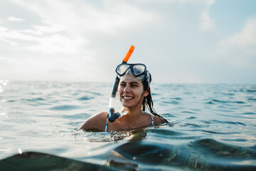 Young caucasian woman with scuba diving mask swimming in the sea