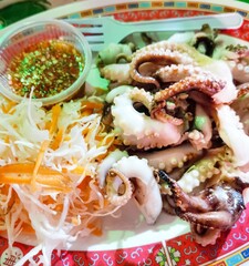 A plate of octopus with a side of vegetables
