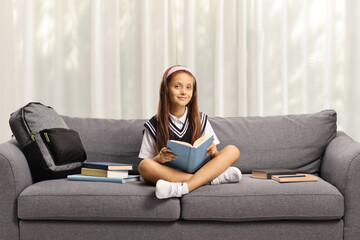 Obraz premium Schoolgirl in a uniform sitting on a couch