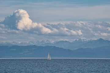 Segelboot auf dem Bodensee vor Alpen mit Schnee