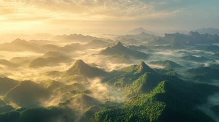 Aerial panorama of a mountain range at sunrise, with misty valleys and peaks bathed in golden light.