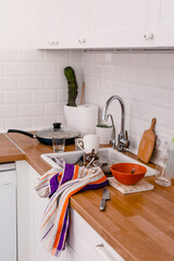 Clutter, dirty dishes by the sink in the white kitchen