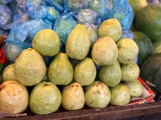 Guava fruits for sale in the market.A bunch of fresh and ripe fruits are for sale .Fruits stall at fruit market.Fruits backgrounds
