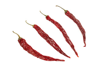 Four dried chili peppers on white background