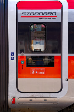 Red and silver colored high speed train named Frecciarossa arriving at railway station of Italian City of Bozen on a sunny summer day. Photo taken July 17th, 2024, Bolzano Bozen, Italy.