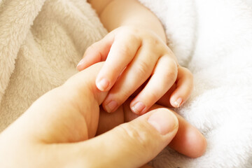 baby's hand gripping adult finger