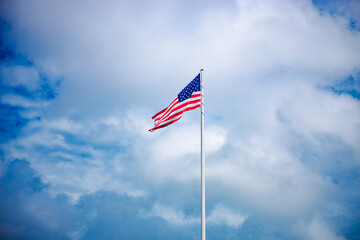 Naklejka premium Patriotic waving american flag in overcast cloudy day