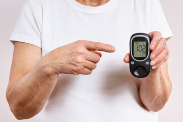 Senior woman and glucometer with result of sugar level. Diabetes in old age