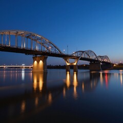 Fototapeta premium Sleek steel arches of Hoan Bridge illuminate at dusk over the Milwaukee River with soft LED light reflections on the waters surface
