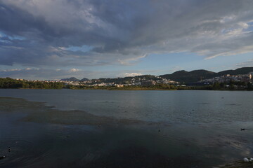 Grande parco di tirana al tramonto, vista su lago, alberi e montagne