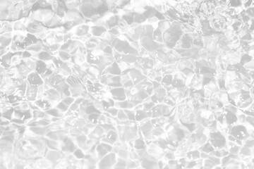 White water with ripples on the surface. Defocus blurred transparent white colored clear calm water surface texture with splashes and bubbles. Water waves with shining pattern texture background.