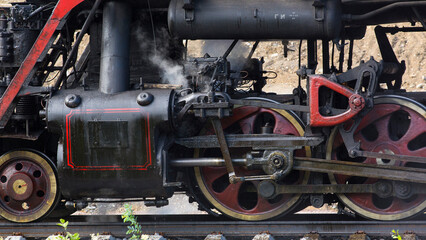 Close-up of part of an old black steam locomotive