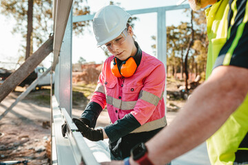 Young female construction worker using her level tool.