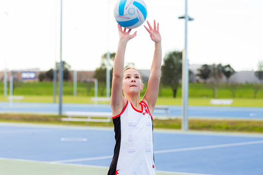 School aged netball player catching ball on court