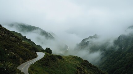 Fog flowing across a winding mountain road, with the peaks shrouded in mist, creating a sense of adventure and mystery. 81c19f91