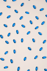 Blue pills and capsules scattered. Concept of medicine, healthcare, and pharmaceutical industry