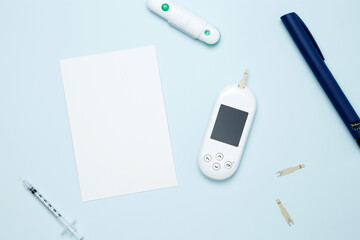 Diabetes concept with glucometer, syringe pen with insulin, blood test strips. Mock up white paper....
