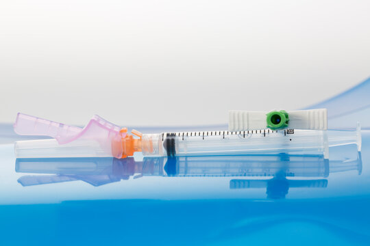 Parts of pressure injectable multilumen peripherally inserted central catheter kit. Tear-Away introducer and syringe.