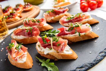 Crostini di pane con crema di formaggio e prosciutto crudo, antipasti italiani, gastronomia europea 