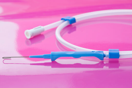 Parts of sterile, single-use vascular access guidewire to guide the catheter into place during central venous catheter insertions on pink background