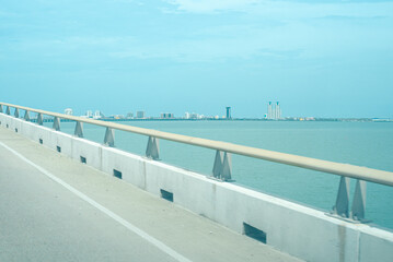 Right side of The Queen Isabella Memorial Bridge or Queen Isabella Causeway over Gulf Coast with downtown South Padre Island buildings background, concrete pier-and-beam bridge from Port Isabel