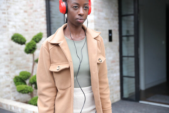 Woman wearing headphones in front of building