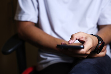 Male hands using a smartphone or tablet in a room. Holding hands. Black background. Home office. For work. for social media or looking for information.