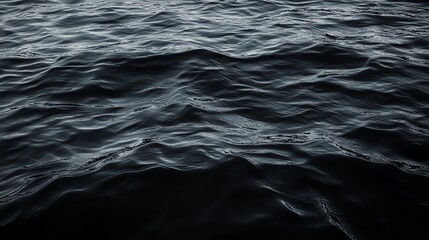 Obraz premium Close-up view of dark water with subtle waves, creating a serene and calm atmosphere perfect for nature-focused projects.