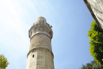 The minaret of the Ağa Mosque in the historic city of Gaziantep, photographed from the bottom up. Traditional Islamic architecture of Turkish Mesopotamia: carved decoration on the minaret.