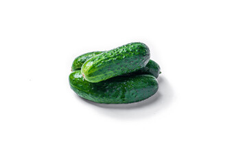 A bunch of cucumbers are piled on top of each other. The cucumbers are green and fresh