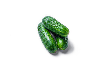 A bunch of cucumbers are piled on top of each other. The cucumbers are green and fresh