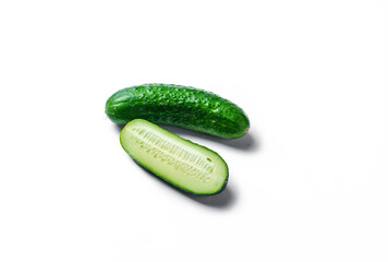 Three cucumbers are cut in half and placed on a white background. The cucumbers are fresh and green, and they are arranged in a way that makes them look like they are ready to be eaten