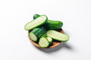 Three cucumbers are cut in half and placed on a white background. The cucumbers are fresh and green, and they are arranged in a way that makes them look like they are ready to be eaten