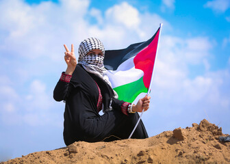 A woman carrying the Palestinian flag 