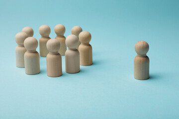 Loneliness concept. Human figure distant from others on light blue background