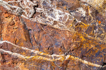 Textured granite stone with cracks and white stripes
