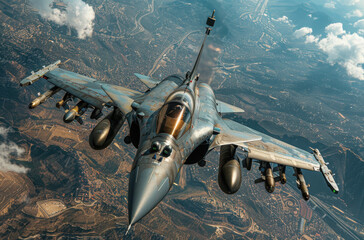 Military plane flies over Indian landscape with underwing ordnance visible