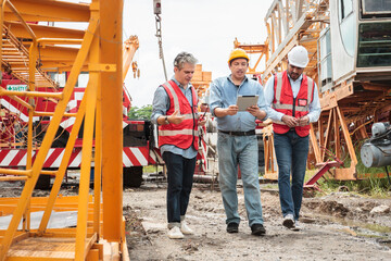 Team of workers at construction site with heavy machines.