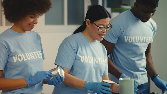 Friendly refugee shelter workers offering hot meals to poor people, volunteering