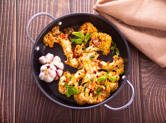 Cauliflower steak with spices and herbs cooked in the oven. Healthy vegan organic cuisine.