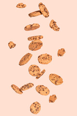 Chocolate cookies levitate on a light orange background. Food concept.