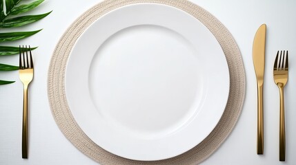 This stylish table setting features a beige plate and golden cutlery on a white linen placemat, accented with lush tropical palm leaves, perfect for a chic dining experience