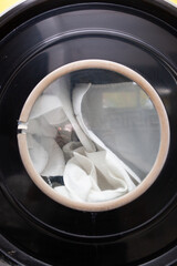 Close shot on washing laundry in big launderette no face