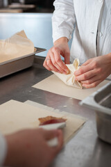Close shot for preparing filo pastry pouches in restaurant kitchen, no face
