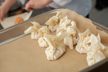Close shot for preparing filo pastry pouches in restaurant kitchen, no face